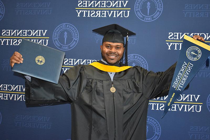 A student wearing his cap and gown for graduation